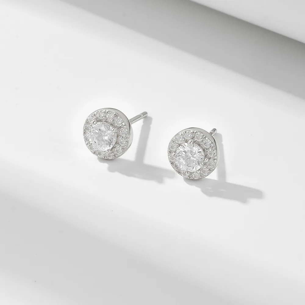 Sterling silver halo stud earrings with round-cut cubic zirconia center stones, classic and timeless design.