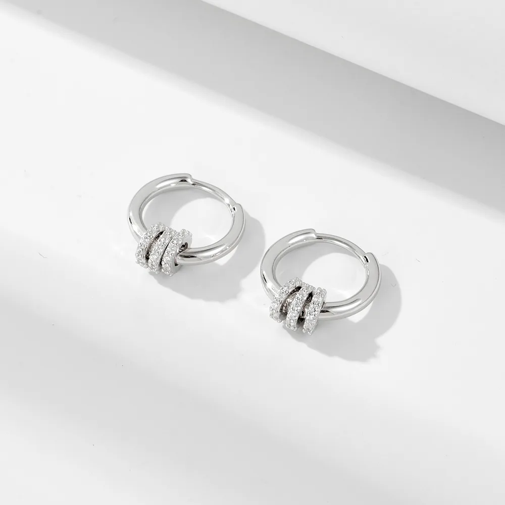 Sterling silver hoop earrings with triple ring design, modern minimalist jewelry with pavé cubic zirconia accents.