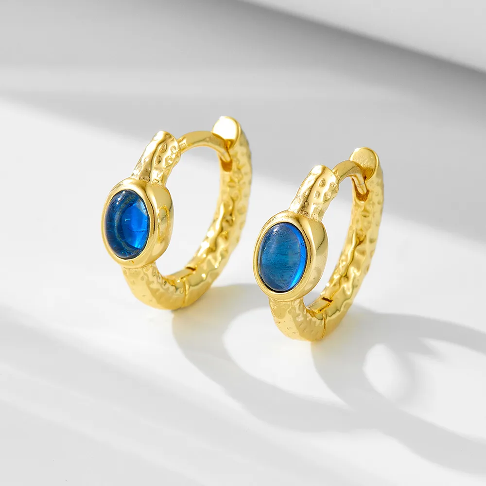 Gold hammered hoop earrings with oval blue gemstone, elegant handcrafted jewelry by Dorji Jewelry.