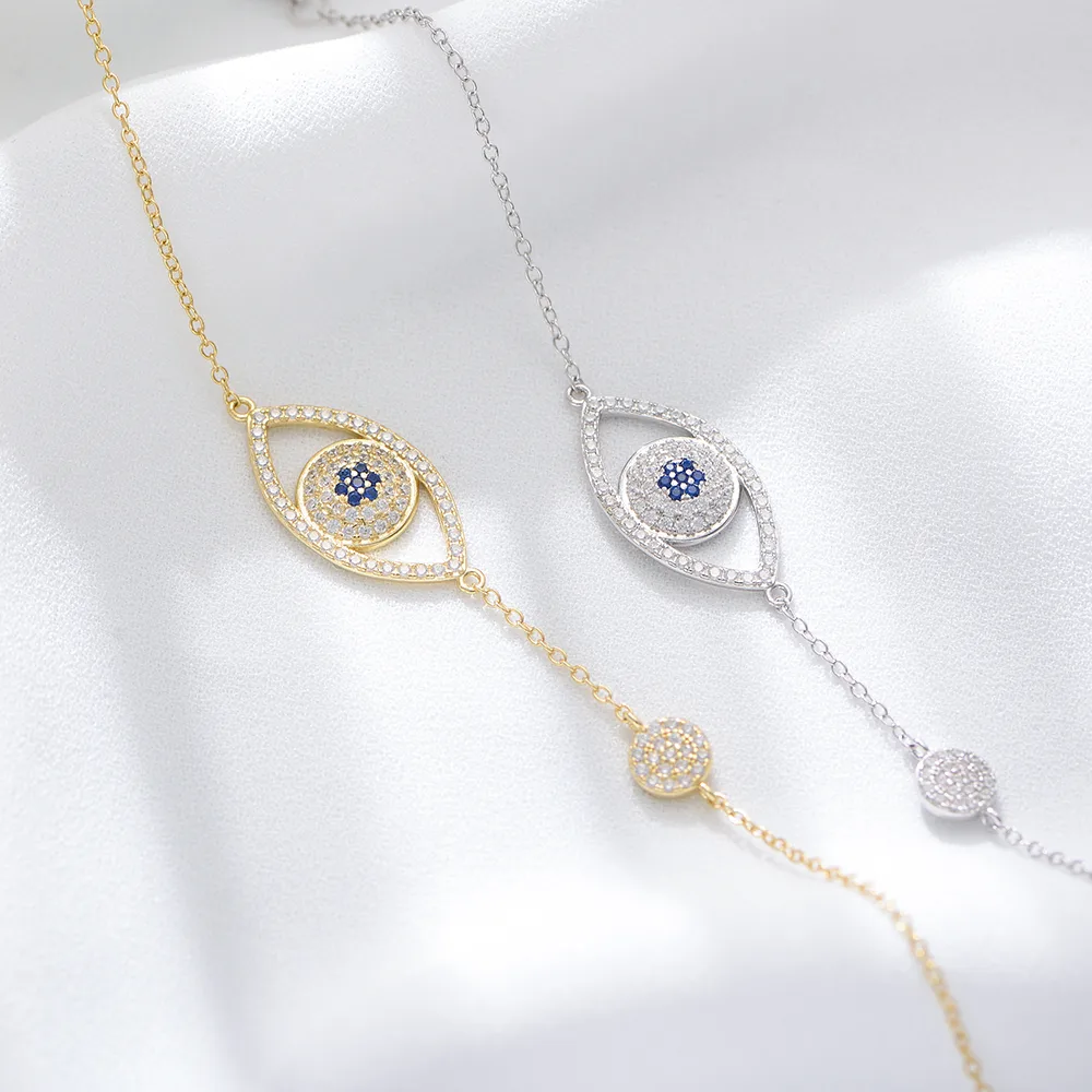 Evil eye bracelet in gold and silver tones with blue cubic zirconia, symbolic jewelry for protection and style.