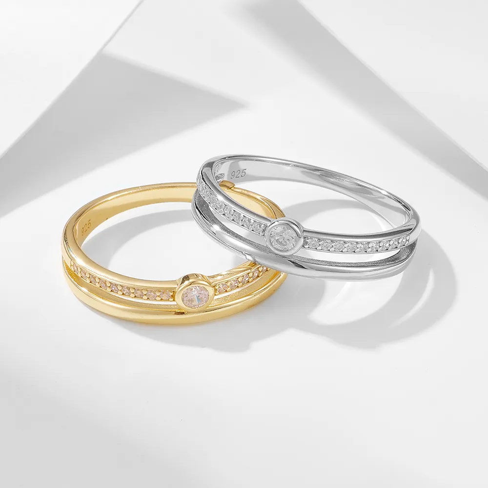 Minimalist gold and silver stacking rings with bezel-set cubic zirconia and slim pavé bands.